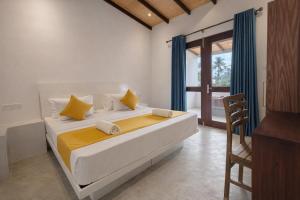 a bedroom with a large white bed with yellow pillows at Paragon Villa Madiha in Matara