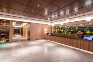 a lobby of a hotel with a painting on the wall at Orange Hotel Kunshan MixC Hotel in Kunshan