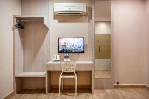 a room with a desk with a television and a chair at Lavender Inn Nusa Bestari in Johor Bahru +21 photos