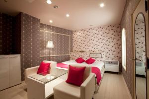 a bedroom with a large bed with red pillows at ホテルラフィネ in Toyonaka