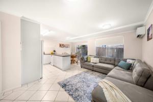 a living room with a couch and a kitchen at Sunshine Hideaway - Easy Beachside Living in Mooloolaba