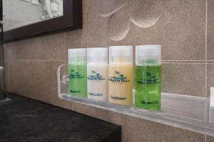 a shelf with four bottles of green and white liquids at Paragon Villa Madiha in Matara