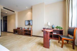 ein Zimmer mit einem Schreibtisch, einem Tisch und einem Stuhl in der Unterkunft Minghua Hotel in Wen-su-lao-ch'eng + 7 Fotos