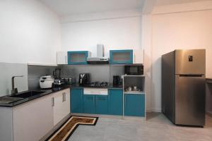 a kitchen with blue cabinets and a refrigerator at Paragon Villa Madiha in Matara +24 photos