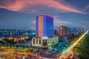 ein beleuchtetes Gebäude in einer Stadt bei Nacht in der Unterkunft Minghua Hotel in Wen-su-lao-ch'eng