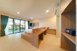 a bedroom with a bed and a desk and a tv at Samed Amoris Resort & Pool Villas in Ko Samed