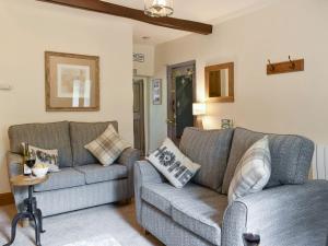 a living room with two couches and a table at Rose Cottage - Uk34067 in Grassington