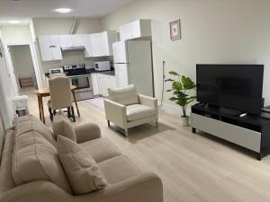 a living room with a couch and a flat screen tv at Cozy Home in Surrey +26 photos