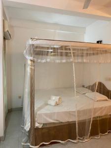 a bed with a canopy in a room at DEMITHA guest in Ranna