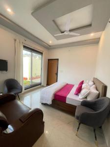 a bedroom with a bed and two chairs at villa Belmond with private pool in Udaipur +13 photos