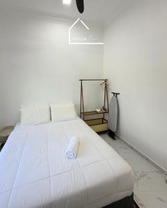 a white bed with a white pillow on top of it at Teratak Zara in Kota Tinggi