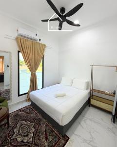 a bedroom with a bed with a ceiling fan at Teratak Zara in Kota Tinggi