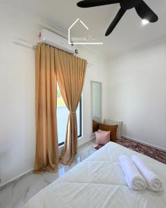 a bedroom with a large white bed and a window at Teratak Zara in Kota Tinggi