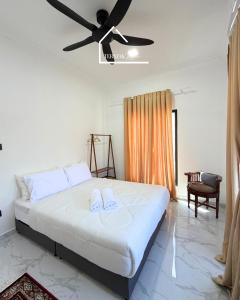 a bedroom with a bed with a ceiling fan at Teratak Zara in Kota Tinggi