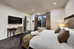 a bedroom with a large bed and a desk with a computer at Attika Hotel in Perth +14 photos