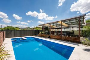 a swimming pool in front of a house at Ironbark Oasis - Serene Poolside Haven by Mudgee CBD in Mudgee