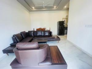 a living room with a leather couch and a table at villa Belmond with private pool in Udaipur