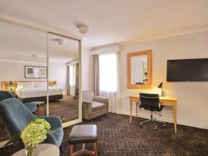 a hotel room with a bed and a desk at Rendezvous Hotel Sydney The Rocks in Sydney