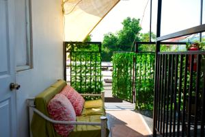 a porch with a green couch and a window at Hostal Estadio Nacional in Santiago