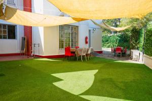 a patio with green grass and a table and chairs at Hostal Estadio Nacional in Santiago