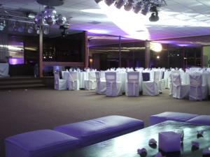 a banquet hall with white tables and white chairs at El Mirador Hotel & Spa in Colonia del Sacramento