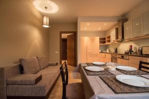 a kitchen and dining room with a table and a couch at Old Riga Galleria Apartment in Riga