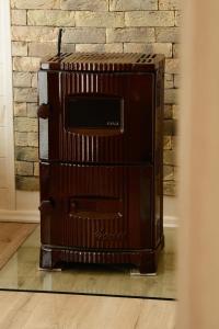 a wooden stove in a room with a brick wall at Легіт in Khashchovanoye