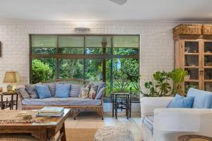 a living room with blue pillows and a couch at Coorabell House in Ewingsdale