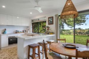 a kitchen and dining room with a table and chairs at Coorabell House in Ewingsdale