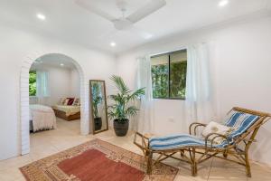 a living room with a chair and a bedroom at Coorabell House in Ewingsdale