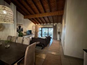 a living room with a couch and a dining table at Oubaai golf eatate in Herolds Bay