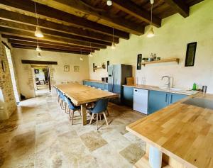 a large kitchen with a wooden table and blue cabinets at La pommeraie in Château-Chervix