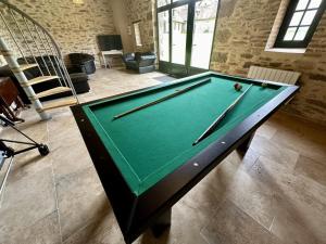 a pool table with cue sticks on top of it at La pommeraie in Château-Chervix