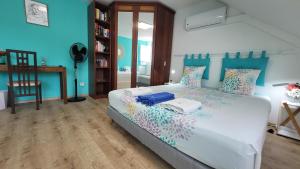 a bedroom with a large bed with blue walls at La Maison des Hôtes in Saint-Joseph +65 photos