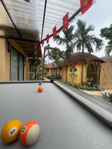 a pool table with balls on it in front of a house at Charming - attractive - pristine nature - peaceful in Vũ Lâm