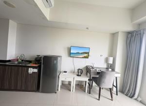a kitchen with a desk and a table with a computer at Studio Bogor Icon Apt wifi&pool in Kedunghalang