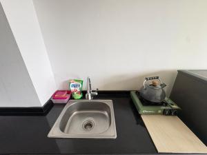a kitchen sink with a tea pot next to it at Studio Bogor Icon Apt wifi&pool in Kedunghalang +10 photos