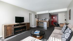 a living room with a couch and a flat screen tv at Adara Hotel in Whistler