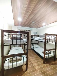 a room with three bunk beds in a room at Mizpah Apartelle in Tagbilaran City