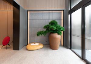 a plant in a large vase in a room at JI Hotel Suzhou Wujiang Development Zone in Suzhou