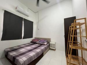 a bedroom with a bed in the corner of a room at LAMAN SUZY Seri Iskandar in Seri Iskandar