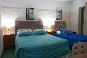 a bedroom with two beds with blue sheets at Hostal Estadio Nacional in Santiago