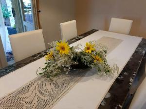 a table with a vase of yellow flowers on it at Villa With Private Pool In Umbria in Umbertide