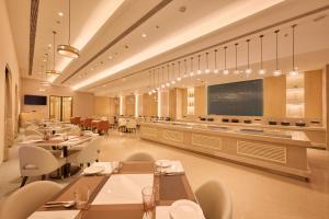 a restaurant with tables and chairs and a large screen at Skywings Sarovar Portico Mathura in Mathura
