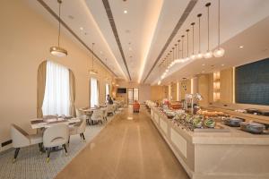 a restaurant with a buffet line with tables and chairs at Skywings Sarovar Portico Mathura in Mathura