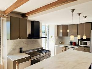 a kitchen with a stove and a counter top at House And Playful Barn in Verrières