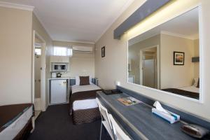 a hotel room with two beds and a mirror at Mineral Sands Motel in Maryborough