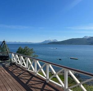 a view of a large body of water with mountains at Northern Lights View Cabin With Big Veranda in Ballangen