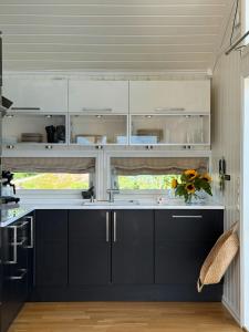 a kitchen with black and white cabinets and a sink at Northern Lights View Cabin With Big Veranda in Ballangen