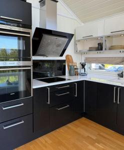 a kitchen with black and white cabinets and a stove at Northern Lights View Cabin With Big Veranda in Ballangen